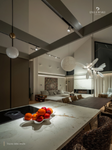 Nowoczesny salon w domu pod Warszawą z oświetleniem zaprojektowanym przez DYLEWSKI Lighting. Na zdjęciu widać sofę, stół i lampy.